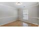 Neutral-toned bedroom with natural light, chair rail, and light wood floors offer a serene atmosphere at 7815 Ambleside Dr, Charlotte, NC 28216