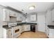 Functional kitchen featuring white cabinets, contrasting countertops, modern appliances, and wood-look floors at 7815 Ambleside Dr, Charlotte, NC 28216