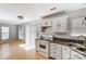 Open kitchen showcasing white appliances, dark counters, and light wood flooring adjoining a bright living space at 7815 Ambleside Dr, Charlotte, NC 28216