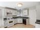 Well-lit kitchen with white cabinets, black appliances, and light wood floors, creating a clean and functional space at 7815 Ambleside Dr, Charlotte, NC 28216