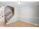 Inviting living room with a staircase, light wood floors, and neutral walls, ideal for comfortable living at 7815 Ambleside Dr, Charlotte, NC 28216