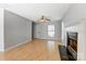 Light and airy living room with gleaming hardwood floors, a cozy fireplace, and a view of the front door at 7815 Ambleside Dr, Charlotte, NC 28216