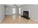 Living room boasts a fireplace, gleaming hardwood floors, and ample natural light from multiple windows at 7815 Ambleside Dr, Charlotte, NC 28216