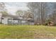 Expansive backyard with a wooden deck, an enclosed porch, a playhouse and mature trees at 10101 Woodview Cir, Charlotte, NC 28277