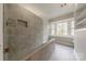 Modern tiled shower with glass partition and convenient built-in niche for toiletries, creating a sleek design at 10101 Woodview Cir, Charlotte, NC 28277