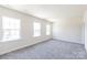 A large bedroom with natural light, carpeted floors, and neutral-colored walls at 104 Kentmore Dr, Waxhaw, NC 28173