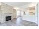 Cozy living room with a gas fireplace, white brick surround, and wood-look floors at 104 Kentmore Dr, Waxhaw, NC 28173