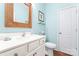 Charming half-bath features a white vanity, toilet, decorative mirror, and coastal-inspired decor on light blue walls at 11124 Chapeclane Rd, Charlotte, NC 28278