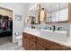 Modern bathroom with double sinks, wood cabinets, and a door to the walk-in closet at 11124 Chapeclane Rd, Charlotte, NC 28278