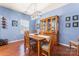Inviting dining room featuring hardwood floors, modern lighting, and a charming display cabinet at 11124 Chapeclane Rd, Charlotte, NC 28278