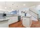 Bright eat-in kitchen features white cabinets, stainless steel appliances, granite counters, and a kitchen island at 11124 Chapeclane Rd, Charlotte, NC 28278
