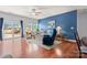 Bright living room with a blue accent wall, hardwood floors, and sliding glass doors to the yard at 11124 Chapeclane Rd, Charlotte, NC 28278