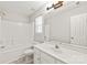 Bright bathroom features a vanity with a single sink and a combination tub and shower with white tile surround at 11404 Larix Dr, Charlotte, NC 28273