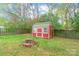 Backyard shed with a small brick firepit and enclosed by a dark wooden fence, perfect for storage at 11404 Larix Dr, Charlotte, NC 28273
