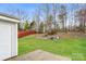 Backyard with a red fence and mature trees behind a house with vinyl siding at 1212 Shenandoah Cir, Rock Hill, SC 29730