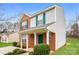 Inviting two-story home featuring a brick facade, green shutters, and a cozy front porch at 1212 Shenandoah Cir, Rock Hill, SC 29730
