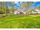 Spacious backyard features a manicured lawn and mature trees, complemented by a charming patio area at 12228 Plover Dr, Charlotte, NC 28269