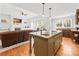Open kitchen featuring a granite island with a cooktop, sink, and stainless steel appliances at 12228 Plover Dr, Charlotte, NC 28269