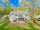 Spacious backyard with a stone patio, deck, lush lawn, and fenced perimeter at 12228 Plover Dr, Charlotte, NC 28269