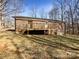 Backyard view showcases the home's brick exterior and expansive deck, set on a lot with mature trees, perfect for outdoor enjoyment at 1420 Hickory Nut Ln, Lincolnton, NC 28092