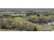 Scenic aerial view of a wooded property with a pond, meadows, and distant homes at 1620 London Rd, Mooresville, NC 28115