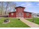 Charming red barn with white trim, surrounded by lush green lawn and stone pathway at 1620 London Rd, Mooresville, NC 28115