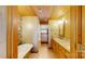Bathroom featuring stone accent wall, tub, and double sink vanity at 1620 London Rd, Mooresville, NC 28115