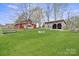 Wide open lot showcasing a grassy lawn and multiple barns with different exterior finishes at 1620 London Rd, Mooresville, NC 28115