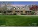 Inviting home featuring a wide porch, a well-kept lawn, and mature trees at 1620 London Rd, Mooresville, NC 28115
