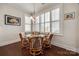 Bright breakfast nook with a glass table, wicker chairs, plantation shutters, and ample natural light, great for casual dining at 17436 Langston Dr, Charlotte, NC 28278