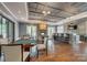 Entertaining space featuring a stone fireplace, bar seating, and a poker table on hardwood floors at 17436 Langston Dr, Charlotte, NC 28278