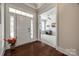 Elegant foyer with hardwood floors, a white front door with sidelights, and open view to the study at 17436 Langston Dr, Charlotte, NC 28278