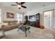 Cozy living room featuring a plush beige sofa, ceiling fan and entertainment center, perfect for relaxing and entertaining guests at 17436 Langston Dr, Charlotte, NC 28278