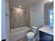 Bright bathroom featuring a combination tub and shower, dark vanity, and tile floors at 2043 Clarksdale St # 31, Charlotte, NC 28206