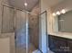 Elegant, tiled shower with a glass door and shower head in a modern bathroom at 2043 Clarksdale St # 31, Charlotte, NC 28206