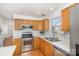 Well-lit kitchen boasts stainless appliances, wood cabinets, and stylish backsplash at 2249 Cigar Ct, Charlotte, NC 28273