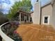 Large wooden deck with a screened-in porch surrounded by a lush flower garden at 319 Vista Grande Cir, Charlotte, NC 28226