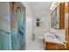 Bright bathroom featuring a marble-patterned shower curtain, white vanity, and tiled floor at 3419 Arrow Ln, Charlotte, NC 28227