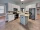 Well-lit kitchen featuring white cabinets, stainless steel appliances, and a central island with granite countertops at 3865 Granite St, Terrell, NC 28682