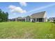 View of the backyard, showcasing the lush green lawn and multiple homes nearby at 4009 Grace Pointe Dr # 101, Indian Trail, NC 28079