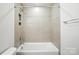 Bathroom with a neutral colored shower-tub and tile walls at 4009 Grace Pointe Dr # 101, Indian Trail, NC 28079