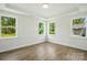 Bedroom with tray ceiling, wood-look floors, and abundant natural light from large windows at 4009 Grace Pointe Dr # 101, Indian Trail, NC 28079