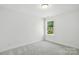 Neutral bedroom features plush carpet and window with backyard view at 4009 Grace Pointe Dr # 101, Indian Trail, NC 28079