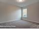 Cozy bedroom with a window, carpeted flooring, and neutral colored walls at 4009 Grace Pointe Dr # 101, Indian Trail, NC 28079