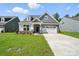 Charming two-story home with a manicured lawn, gray siding and a two-car garage at 4009 Grace Pointe Dr # 101, Indian Trail, NC 28079