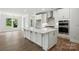 Bright, open-concept kitchen with white cabinets, stainless steel appliances, and a large center island at 4009 Grace Pointe Dr # 101, Indian Trail, NC 28079