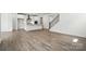Open-concept living room with wood-look flooring, stairs, and white trim at 4009 Grace Pointe Dr # 101, Indian Trail, NC 28079