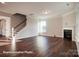 Spacious living room boasting hardwood floors, a cozy fireplace, and staircase access at 4009 Grace Pointe Dr # 101, Indian Trail, NC 28079