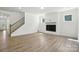 Bright living room with fireplace and wood-look flooring and staircase at 4009 Grace Pointe Dr # 101, Indian Trail, NC 28079