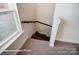 Carpeted staircase with wood railing and natural light from the adjacent window at 4009 Grace Pointe Dr # 101, Indian Trail, NC 28079